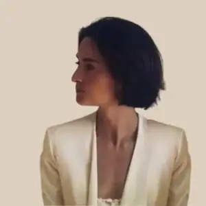 Eenzame vrouw in beige jasje zijaanzicht.