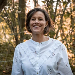 Knappe vrouw in witte blouse buiten.